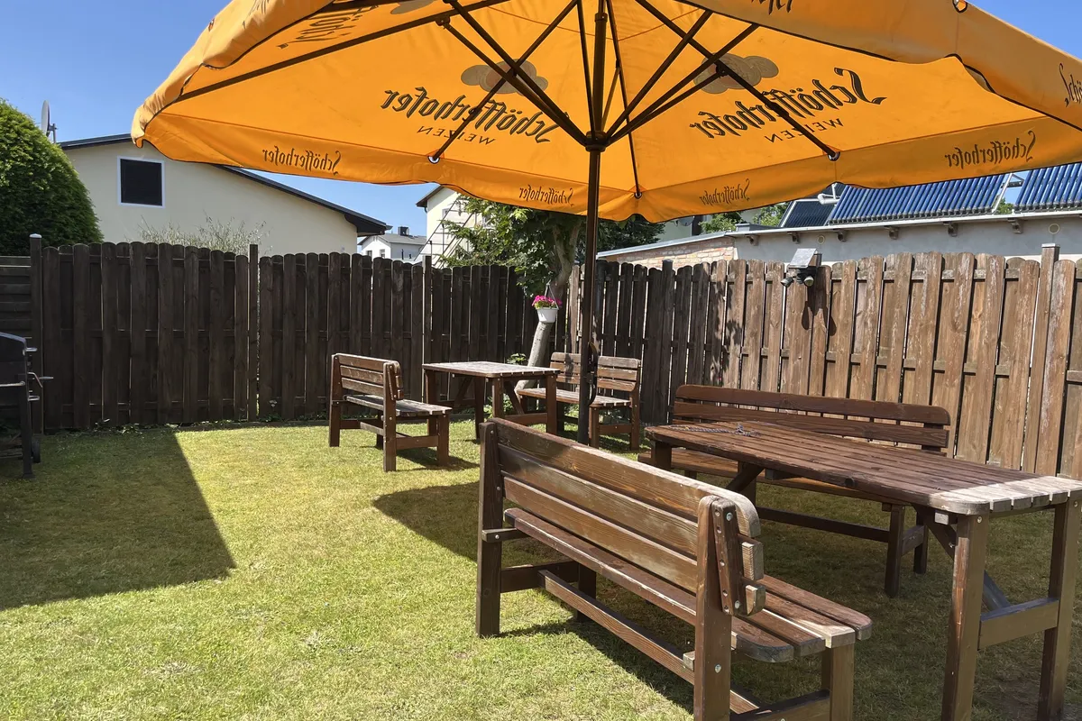 Gemeinsamer Garten beider H&auml;user mit Sitzgruppen und Sonnenschirm